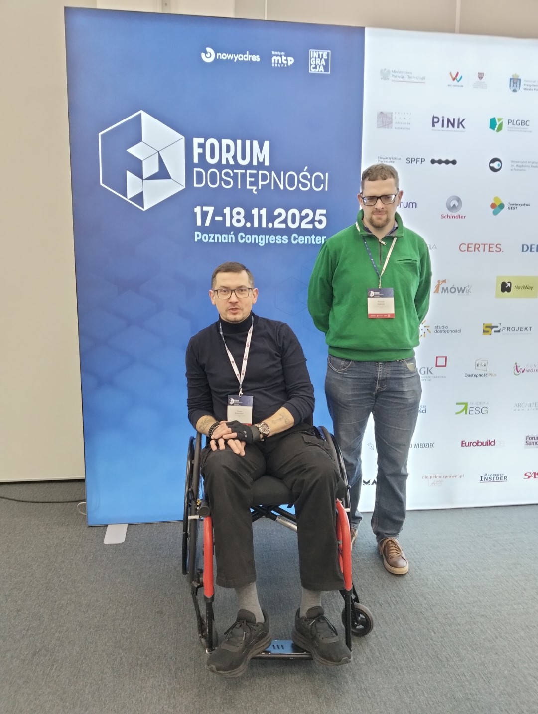 Konrad i Tomasz na tle plakatu Forum Dostępności 2025