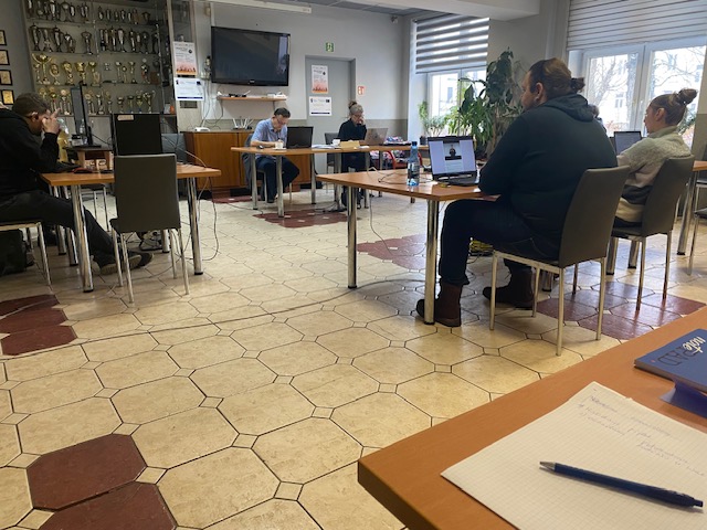 Widok sali, siedzą testowani uczestnicy, komisja egzaminacyjna i testerzy