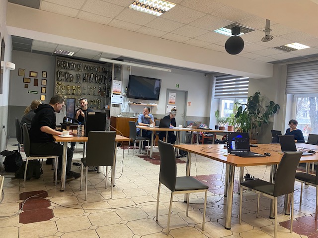 Widok sali, siedzą komisja egzaminacyjna i testerzy oraz analitycy